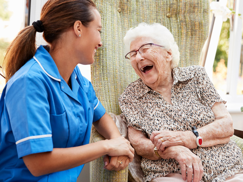 senior woman and nurse laughing