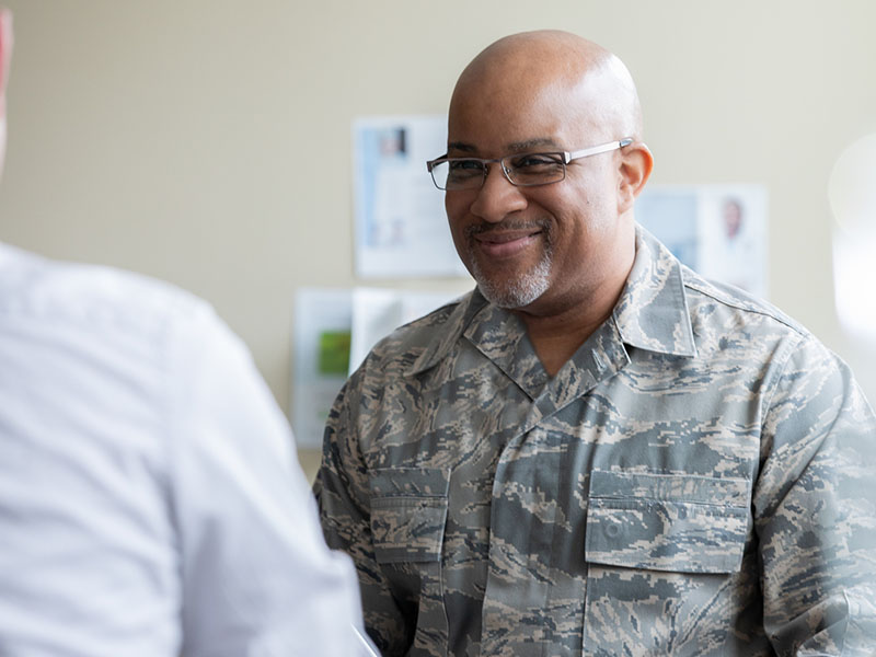 Senior military man smiling during group therapy discussion